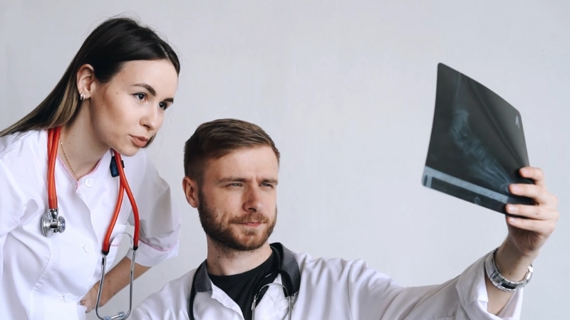 Two doctors review an X-ray during electrodiagnostic testing for meralgia paresthetica