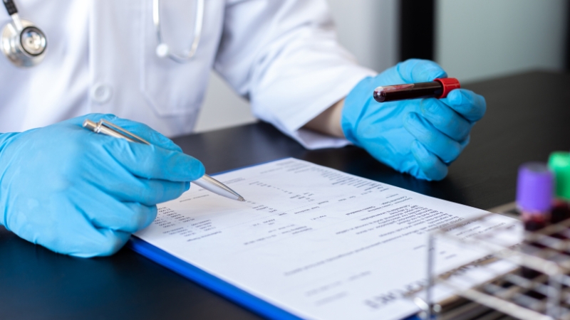 A doctor reviews lab results and a blood sample to check for signs of early iron deficiency in the pre-latent stage